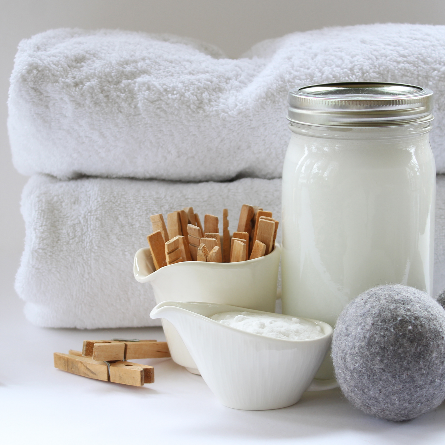Coconut Soap Flakes made in laundry gel in a jar with pegs and towels showing a natural laundry