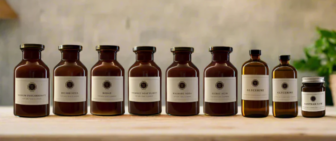 9 DIY green cleaning ingredients from Under Your Sink on a bench all in vintage looking amber glassware