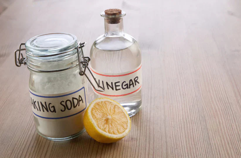 A bottle of vinegar next to jar of Bicarb Soba used for a blog about Why Bicarb and Vinegar aren't used for everything and why they should not be mixed. This is a visual for blog about green cleaning solutions