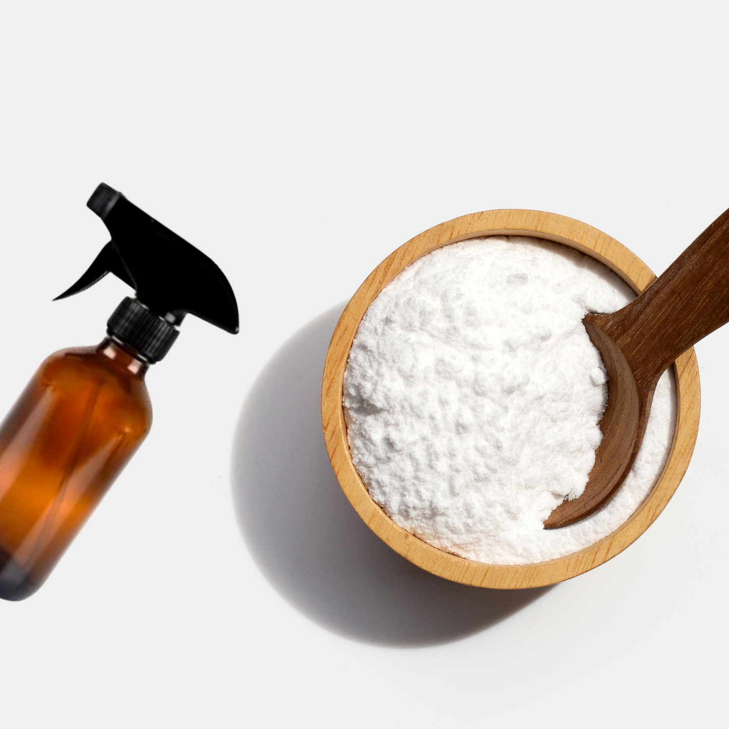 Bicarb Soda powder in a bowl with a amber glass trigger spray for green cleaning