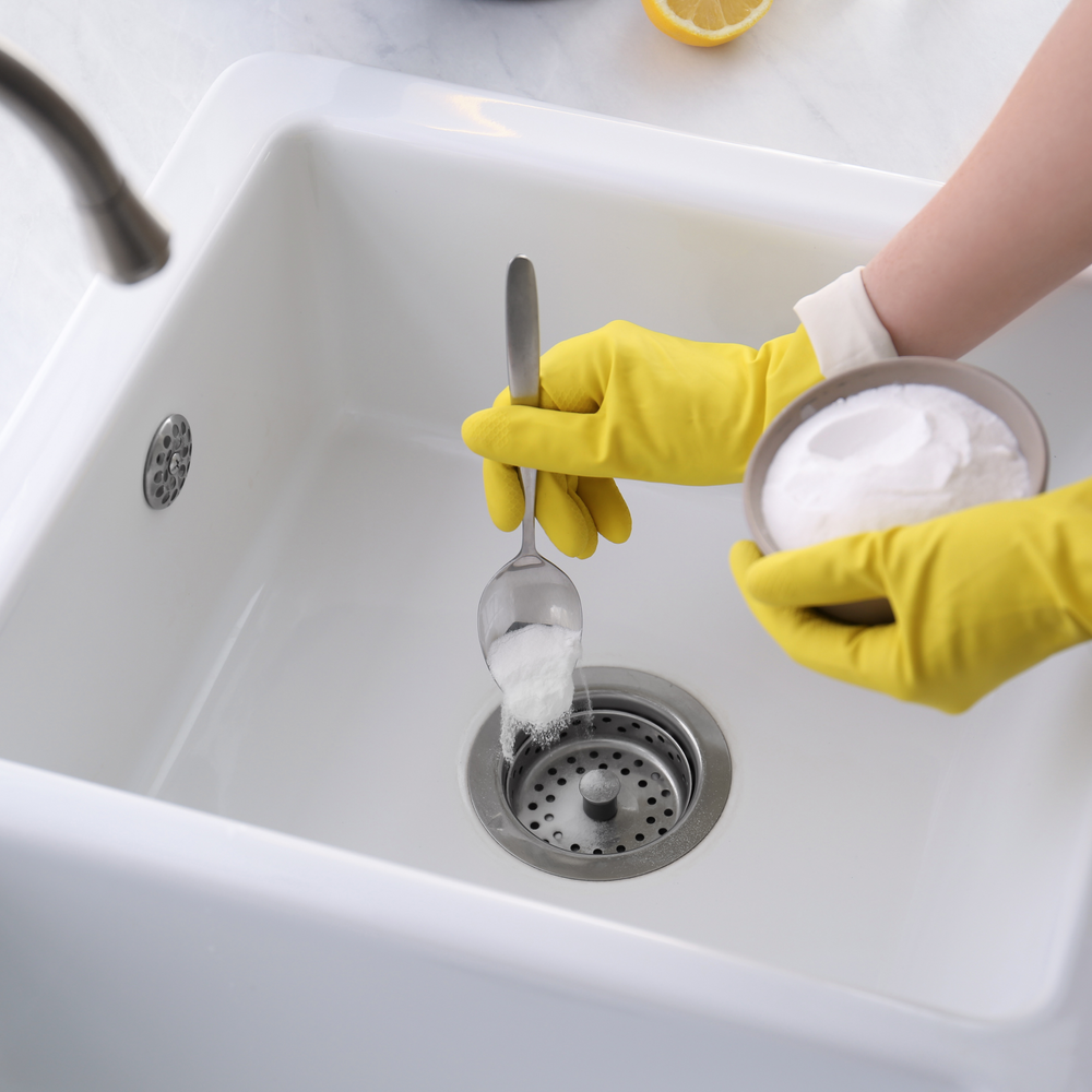 Washing Soda (sodium carbonate) being poured into sink for drain cleaner