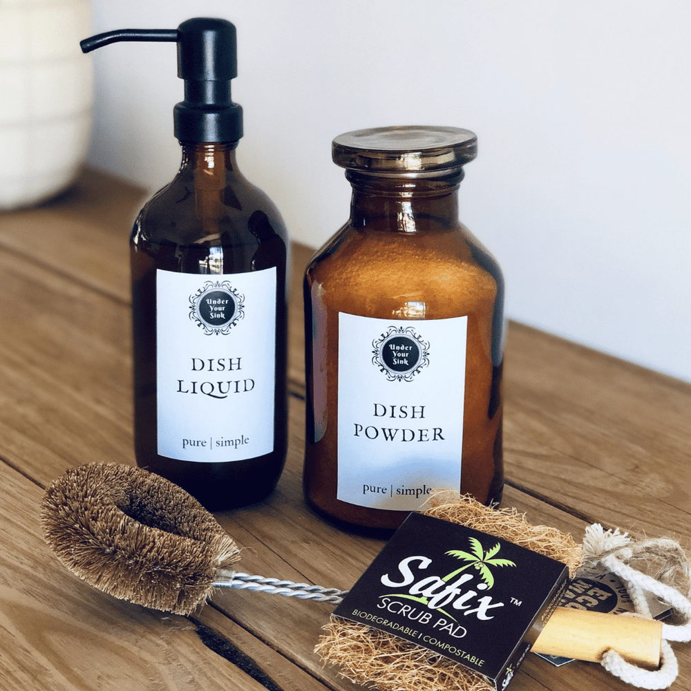 Handmade Dish Liquid and Dish powder on stylish amber glassware with eco-friendly dish brush all for green cleaning