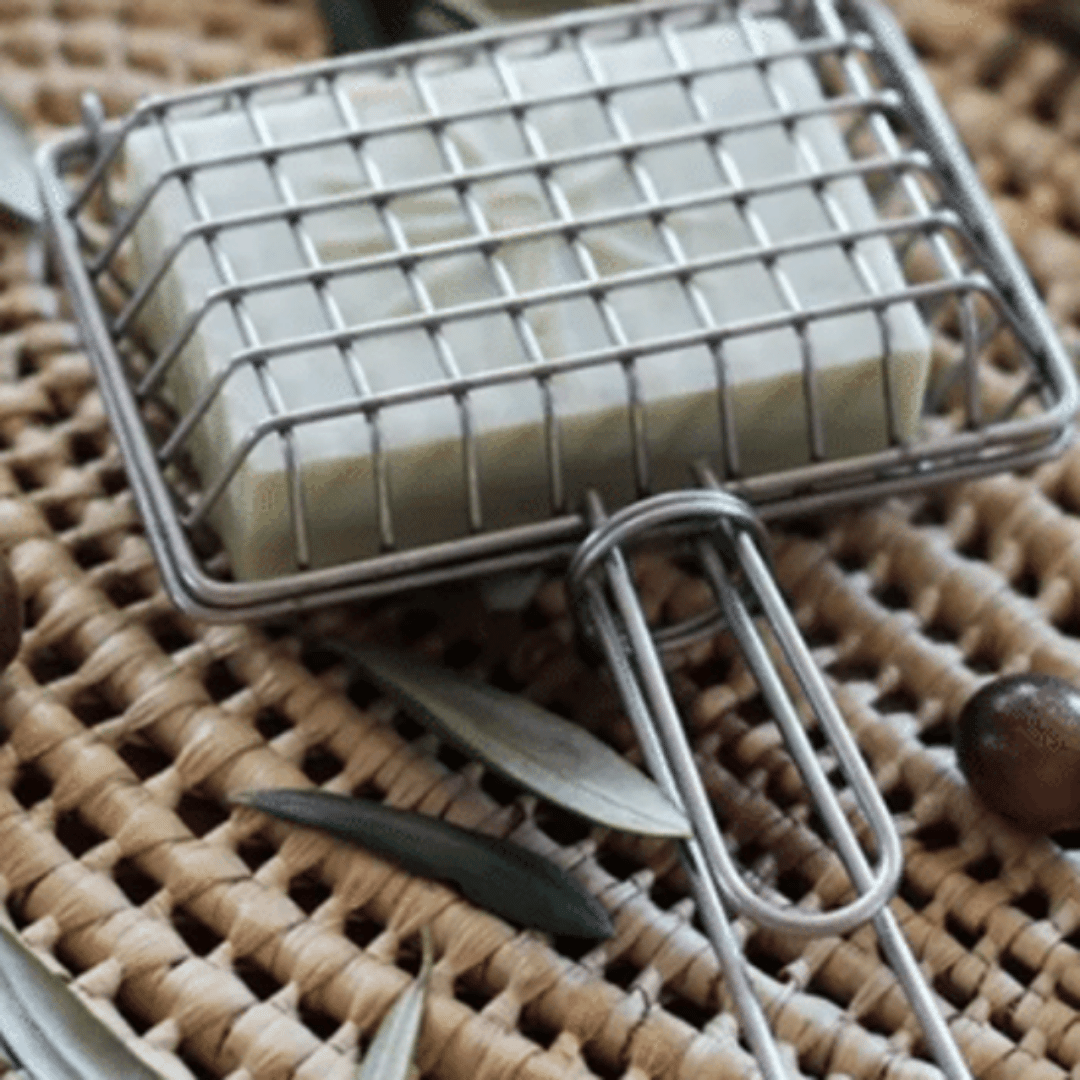 Metal cage with handle used to hold a soap bar to swish in sink for plastic free, zero waste green cleaning