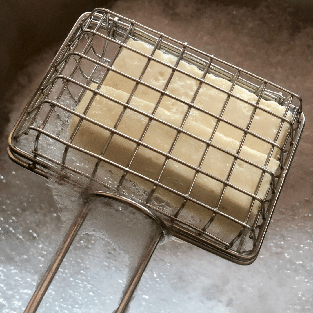 Metal cage with handle used to hold a soap bar to swish in sink for plastic free, zero waste green cleaning